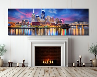 Może przedstawiać: Panoramiczny widok nocnej panoramy Nashville, z charakterystycznymi budynkami miasta oświetlonymi żywymi kolorami. Panorama miasta odbija się w spokojnych wodach rzeki Cumberland, tworząc oszałamiający obraz.