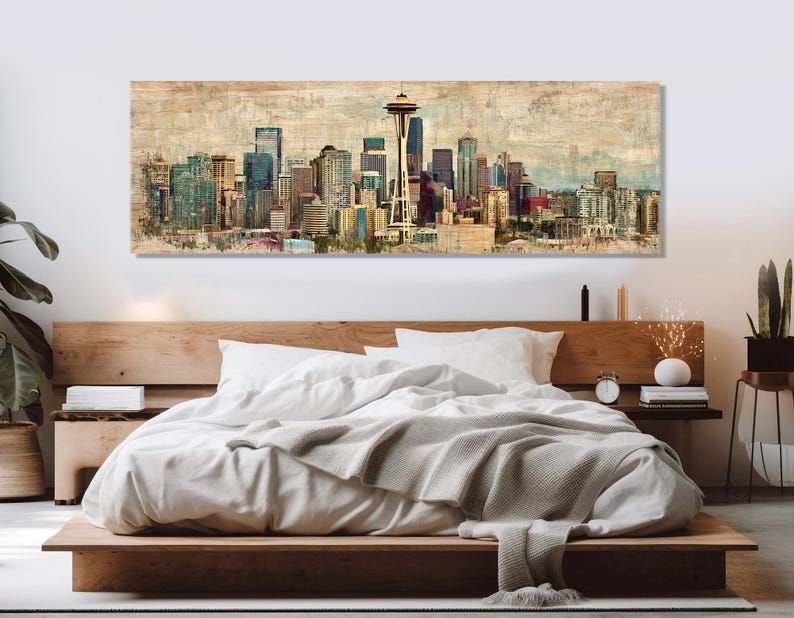 May include: A large rectangular wall art print depicting the Seattle skyline. The artwork features a vintage, textured style with a muted color palette of beige, blue, and brown. The Space Needle is prominently displayed.