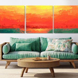 Könnte beinhalten: Ein Triptychon abstrakter Kunstpaneele mit einer lebendigen Farbpalette. Das Kunstwerk zeigt kräftige Pinselstriche in Gelb, Orange, Rot und Türkis, die eine dynamische Komposition erzeugen. Die Paneele werden über einem türkisfarbenen Sofa ausgestellt.