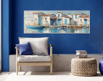 May include: A rectangular wall art print featuring a coastal scene with white buildings, terracotta roofs, and blue doors lining a harbor. Several small blue and brown boats are docked in the calm water, reflecting the structures above.