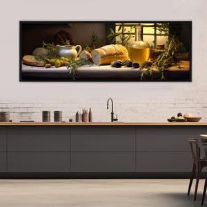 以下が含まれることがあります： パン、オリーブ、水差し、オイルボトルを配した額入りの静物画。温かい光で照らされ、ハーブの小枝が緑を加えている。素朴で地中海風のテーマを連想させ、キッチンを彷彿とさせる構図。