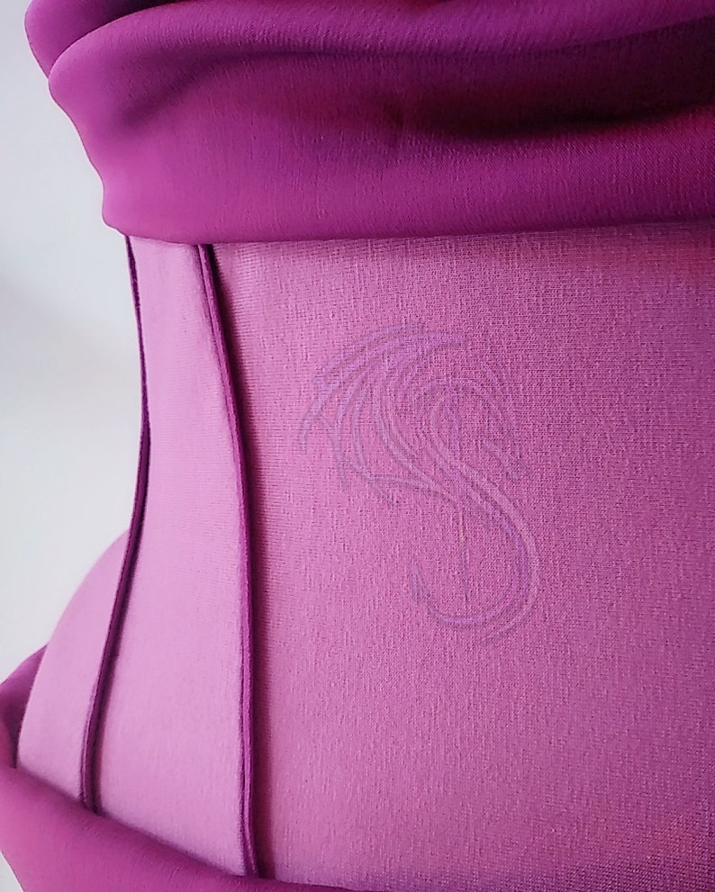 May include: A magenta corset featuring a structured design with vertical seams and a smooth fabric finish. A subtle, tonal embroidered dragon motif is visible on the side panel, adding a delicate texture to the vibrant, solid-colored garment.