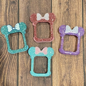 Peut inclure: Quatre bracelets de montre à paillettes avec un motif Minnie Mouse. Les bracelets sont en rose, bleu, turquoise et violet.