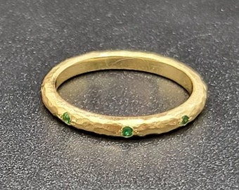 14k solid yellow gold hammered eternity band with 0.11 ct. natural AAA emeralds.