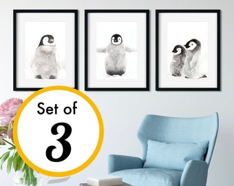 May include: A set of three framed wall art prints featuring black and white watercolor illustrations of penguins. Each print is enclosed in a simple black frame. The text Set of 3 is displayed in a yellow circle overlaying the image.
