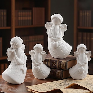Puede incluir: Colección de figuras de ángeles de cerámica blanca. Cada ángel tiene alas y una túnica fluida. Algunos sostienen corazones, otros estrellas. Las figuras varían en tamaño y están dispuestas sobre una mesa con libros y un mapa.