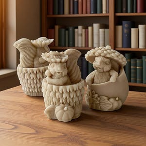 May include: Three beige, sculpted wax figures featuring woodland themes. Two figures depict squirrels nestled within textured, acorn-like containers, while the third figure shows a small creature sheltered under a large, detailed mushroom cap.
