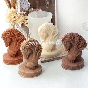 May include: Four horse head candles, two brown and two white, on a light brown surface. The candles are all in the same style, with a detailed horse head design. The candles are all on small, round bases.