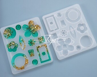 May include: Two clear silicone molds for making resin earrings. The molds feature a variety of shapes, including circles, squares, rectangles, flowers, and leaves. The molds are on a light blue background.
