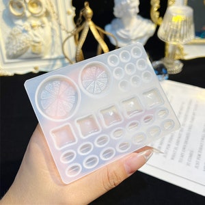May include: A clear silicone mold with various shapes for resin crafting. The mold includes two large lemon slices, multiple squares, ovals, and circles.