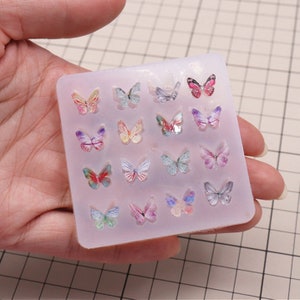 Pu&ograve; includere: Uno stampo in silicone con 16 forme a farfalla. Lo stampo &egrave; trasparente e le farfalle sono di vari colori, tra cui rosa, viola, blu e giallo.