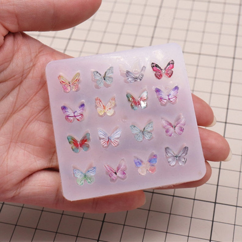 Pu&ograve; includere: Uno stampo in silicone con 16 forme a farfalla. Lo stampo &egrave; trasparente e le farfalle sono di vari colori, tra cui rosa, viola, blu e giallo.