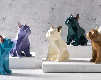 May include: Five geometrically designed figurines of French Bulldogs in various colors, including teal, purple, white, green, and brown. The figurines are arranged on white platforms.