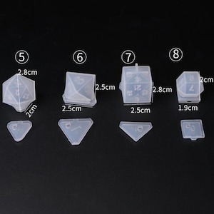 May include: Set of five clear silicone molds for making dice. The molds are numbered 5 through 8 and measure 2.5 cm to 2.8 cm in size.