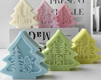 Puede incluir: Cinco jabones con forma de árbol de Navidad en diferentes colores: blanco, rosa, verde claro, azul y amarillo. Cada jabón presenta un diseño diferente, incluyendo un ciervo, un muñeco de nieve y un Papá Noel.