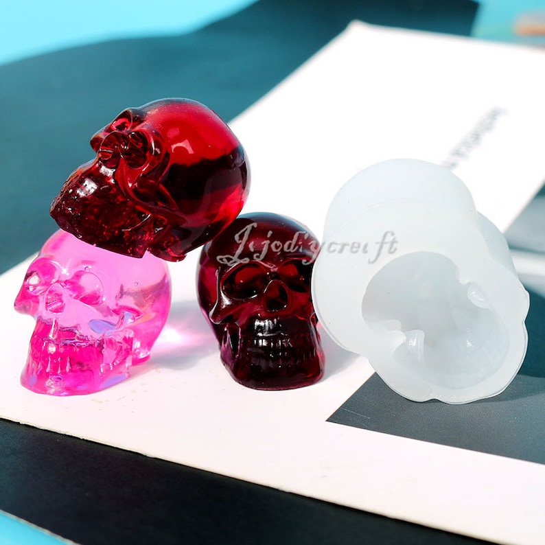 K&ouml;nnte beinhalten: Drei sch&auml;delf&ouml;rmige Harzformen, eine rote, eine rosa und eine wei&szlig;e. Die Formen werden zur Herstellung von Harzhandwerk verwendet.