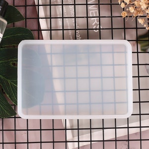 May include: A clear, rectangular silicone mold with a smooth, glossy finish. The mold is designed for crafting and creating resin projects.