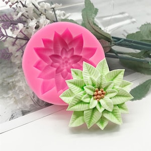Könnte beinhalten: Rosa Silikonform zum Herstellen einer Weihnachtsstern-Blume. Die Form wird mit einer grünen und goldenen Weihnachtsstern-Blume gezeigt, die mit der Form hergestellt wurde.