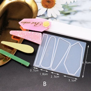 K&ouml;nnte beinhalten: Eine transparente Silikonform mit vier verschiedenen Formen zum Herstellen von Haarklammern. Die Form ist 6,1 cm hoch und die Formen sind 0,7 cm, 1,8 cm, 2,3 cm und 3,1 cm breit.