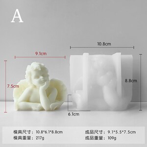 May include: White silicone mould for making a cherub figurine. The mould measures 10.8 cm by 6.1 cm by 8.8 cm. The finished product measures 9.1 cm by 5.5 cm by 7.5 cm.