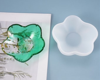 May include: A clear green five-pointed star shaped resin dish with gold flakes inside. A white silicone mold of the same shape is shown next to it.