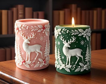 May include: Two cylindrical pillar candles, one light pink and one dark green, each featuring a raised white relief design of a standing deer surrounded by pine trees, snowflakes, and holly leaves with small red berries on the pink candle.