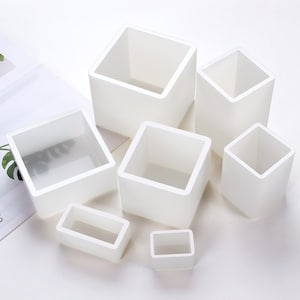 Puede incluir: Un juego de seis moldes de silicona blancos en varias formas cuadradas y rectangulares. Los moldes están diseñados para hacer pequeñas manualidades o proyectos de resina.