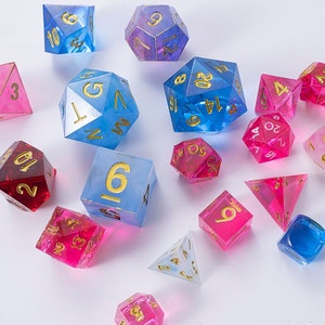 May include: A set of 14 iridescent dice in blue, pink, and purple with gold numbers. The dice are made of clear resin and have a variety of shapes, including cubes, tetrahedrons, and dodecahedrons.