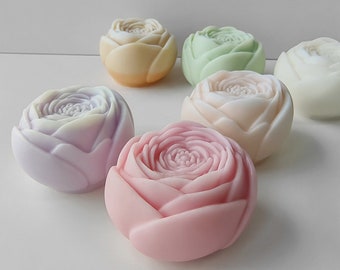 Puede incluir: Seis jabones hechos a mano con forma de rosas en varios colores pastel, incluyendo rosa, morado, amarillo, verde y blanco.