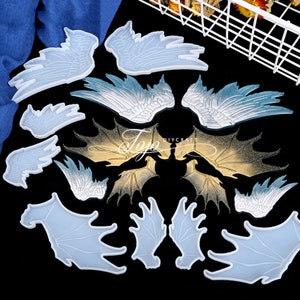 May include: A set of 10 silicone molds for resin casting. The molds are shaped like wings, including angel wings, dragon wings, and bat wings. The molds are translucent and have a smooth surface.