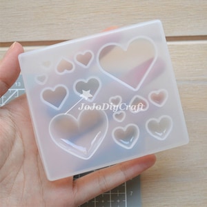 Puede incluir: Molde de silicona transparente con 10 cavidades en forma de corazón de diferentes tamaños. El molde está diseñado para crear artesanías de resina.
