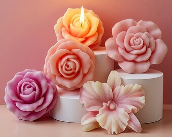 May include: A selection of rose and orchid-shaped candles in shades of pink and orange. One candle is lit, emitting a warm glow. The candles are displayed on white cylindrical pedestals against a soft pink background.