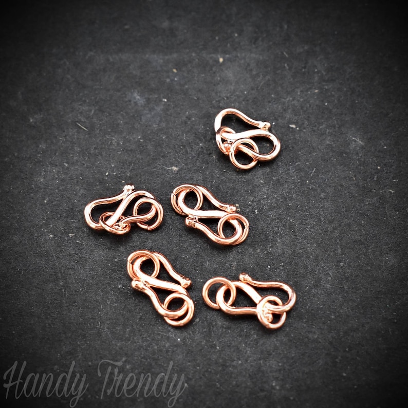 May include: Five rose gold lobster clasps, a type of jewellery finding used for attaching chains or cords to jewellery pieces.