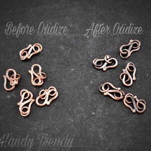 May include: Before and after images of copper-coloured metal clasps. The clasps are in the shape of a figure eight. The clasps on the left are shiny and the clasps on the right are oxidised and have a darker colour.