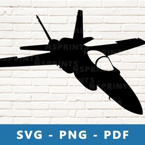 Könnte beinhalten: Eine schwarze Silhouette eines Kampfjets vor einem weißen Ziegelmauerhintergrund. Der Jet fliegt in diagonaler Richtung mit der Nase in Richtung der rechten Seite des Bildes.