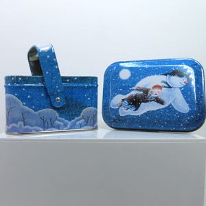 En liten rektangulär vintageburk med handtag från 2005, Raymond Briggs The Snowman.