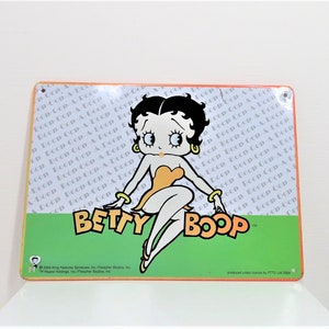 A Betty Boop metal wall plaque.