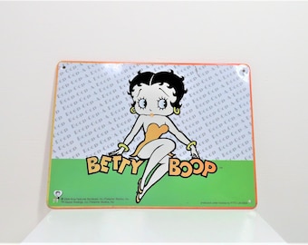 A Betty Boop metal wall plaque.