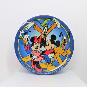 May include: A blue ceramic plate with a yellow border features a cartoon image of Mickey Mouse, Minnie Mouse, Donald Duck, Goofy, and Pluto. The text on the plate reads "NET WT. 14 OZ - DISNEY CHARACTER COOKIES - 400 G POIDS NET".