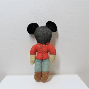 K&ouml;nnte beinhalten: Eine Vintage-Stoffpuppe von Mickey Mouse mit schwarzen Ohren, einem roten Hemd, einer blauen Jeans und braunen Stiefeln.