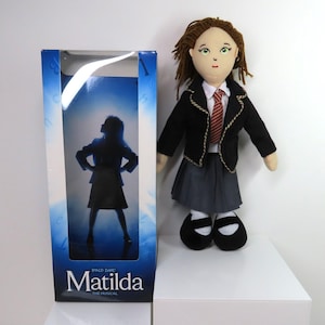 A Roald Dahl Matilda doll in original box.  Matilda The Musical Doll Roald Dahl.
