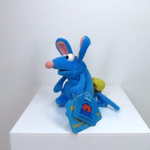 Puede incluir: Marioneta de ratón de peluche azul con orejas grandes y cola amarilla. La marioneta tiene una etiqueta que dice "Bear in the Big Blue House" y "Open Sesame".