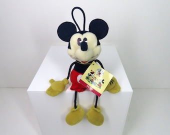A vintage 1990s GUND Mickey Mouse soft toy with string limbs and swing tag.