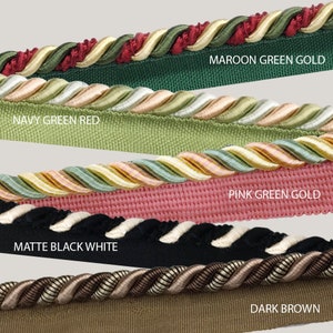 Puede incluir: Primer plano de cinco tipos diferentes de ribetes, cada uno con una combinación de colores diferente. Los ribetes están etiquetados como "MAROON GREEN GOLD", "NAVY GREEN RED", "PINK GREEN GOLD", "MATTE BLACK WHITE" y "DARK BROWN".
