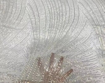 May include: White fabric with a wavy pattern of silver sequins. The fabric is sheer and has a delicate texture.
