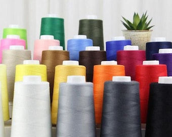 May include: A collection of 24 spools of thread in various colors, including white, black, red, blue, green, yellow, orange, brown, and beige. The spools are arranged in rows and are all the same size.