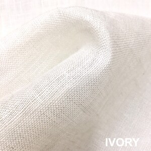 May include: Close-up of a white linen fabric with a woven texture. The fabric is soft and has a subtle sheen. IVORY is written in the bottom right corner of the image.