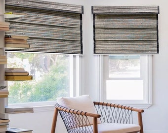 May include: Two woven bamboo blinds with black trim are fitted in a window. A wooden chair with a white cushion sits in front of the window.