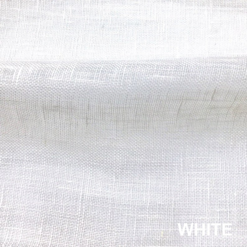 May include: White woven fabric with a textured surface. The fabric is folded in half, creating a crease in the middle.