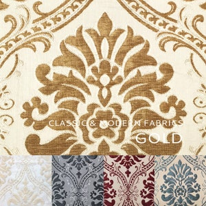 May include: A close-up of a gold damask fabric with a white background. The fabric has a classic and modern design. The text "CLASSIC & MODERN FABRICS GOLD" is printed on the fabric.